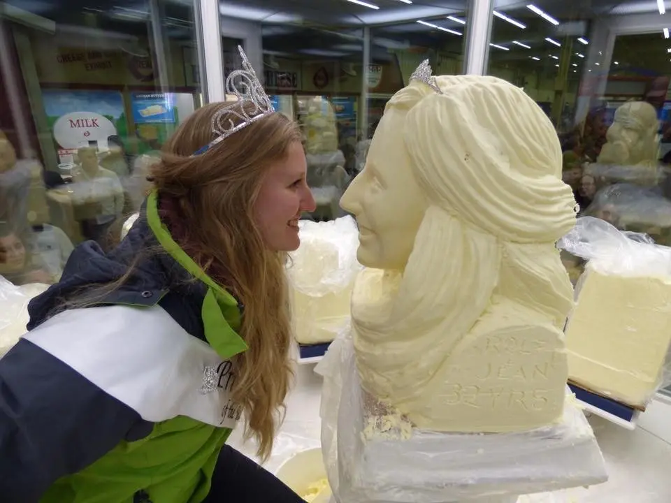 Princess Kay leans in close to examine her likeness carved out of butter.