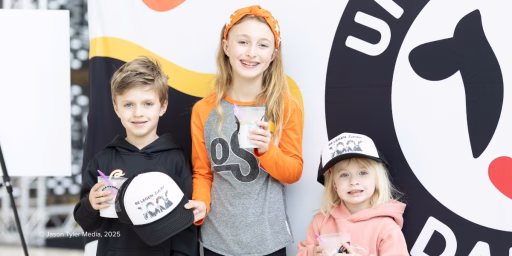 Group of children holding cups of milk and cookies