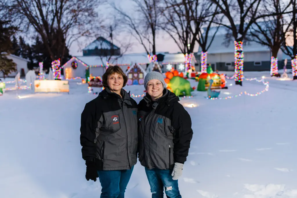 A family poses for a photo in front of Christmas decorations.