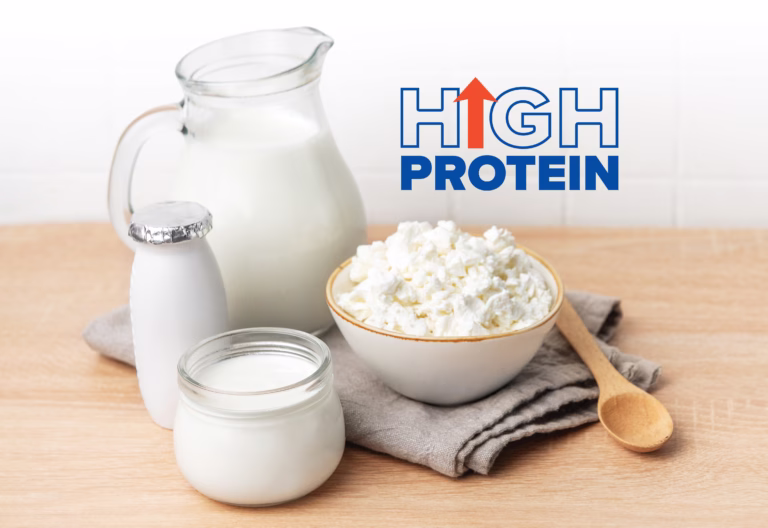 Various fresh dairy products on a wooden counter with white tiles in the background