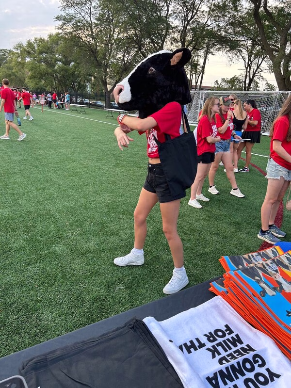 Student dancing with fake cow head on