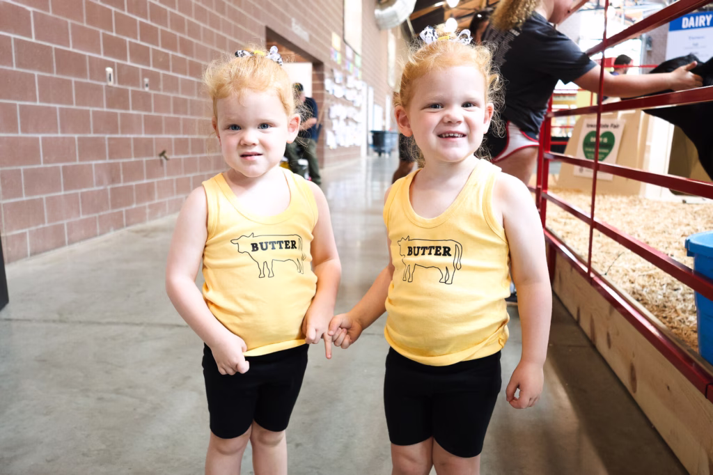 Two young girls wearing butter shirts at the Iowa State Fair