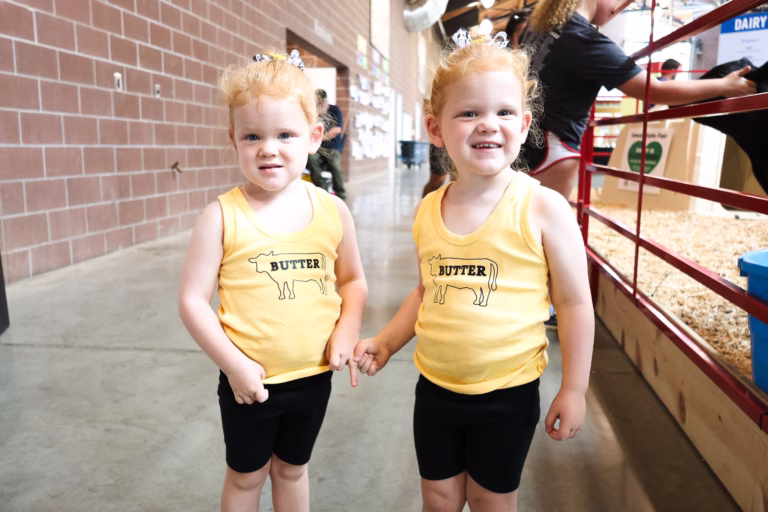 Two young girls wearing butter shirts at the Iowa State Fair