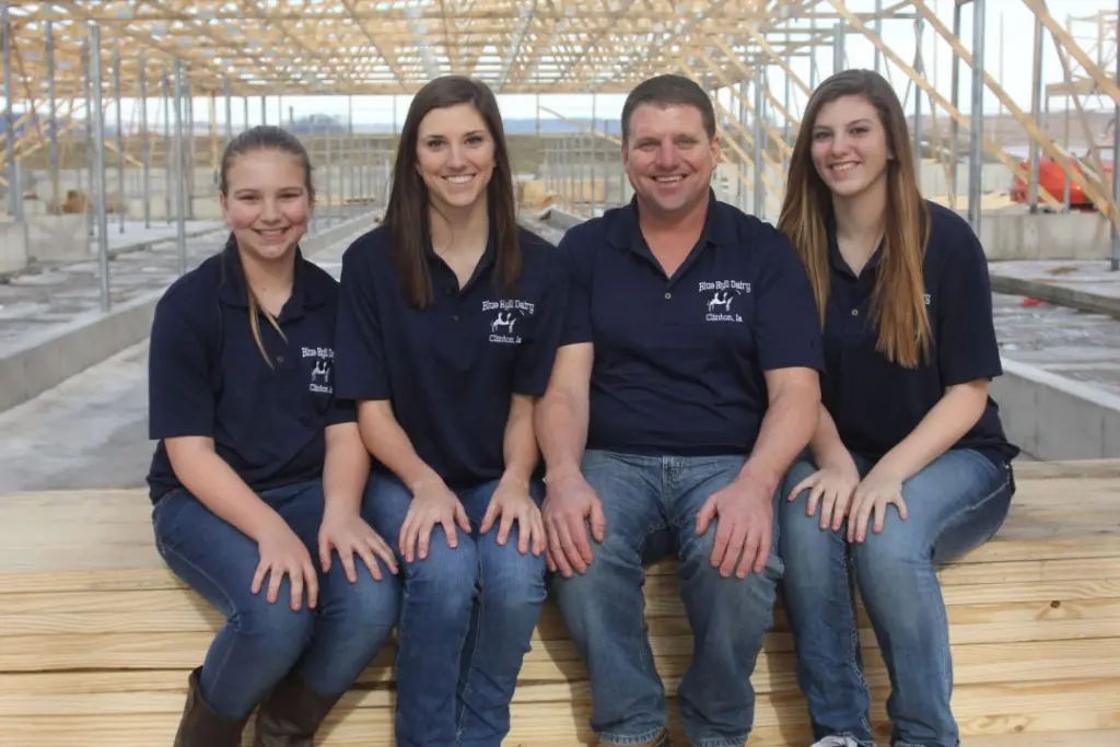 Iowa dairy farmer Marty Burken sits with his three daughters.