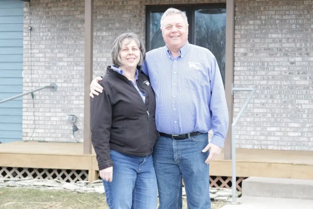 John and Joan Maxwell pose in front of their home.