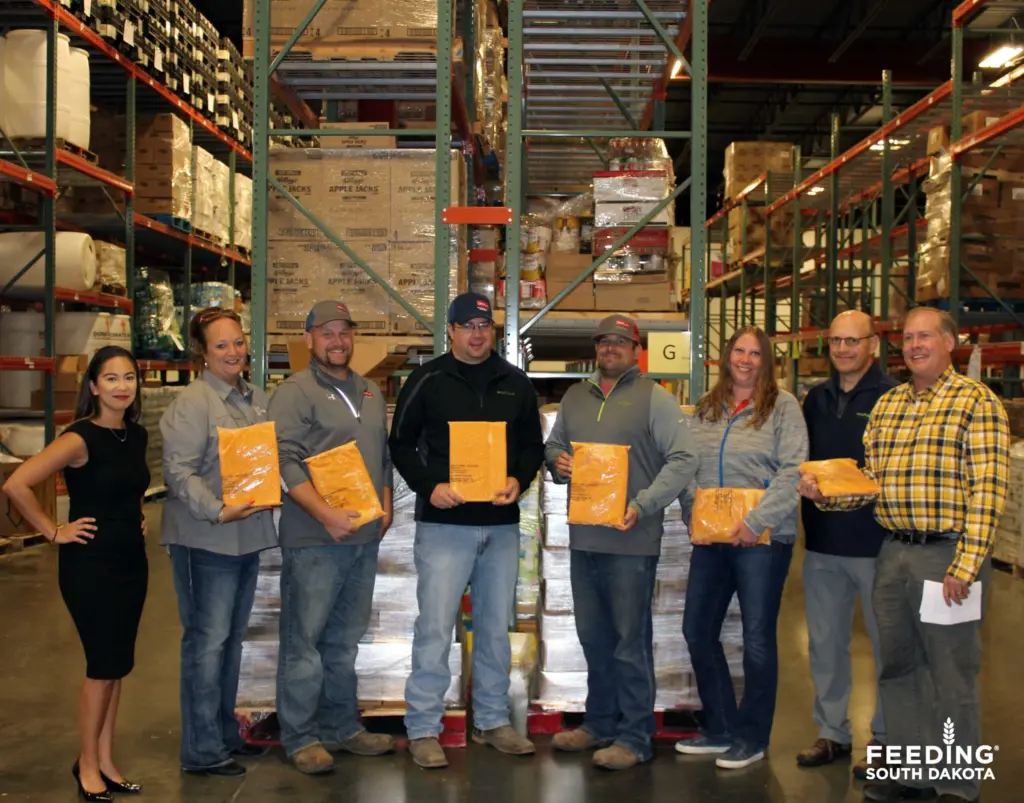 A group of people stand in a warehouse.