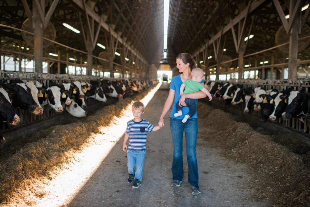 Mom and two sons walking in dairy barn