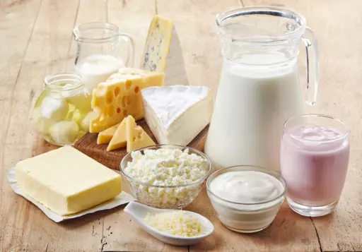 Various fresh dairy products on a wood table.