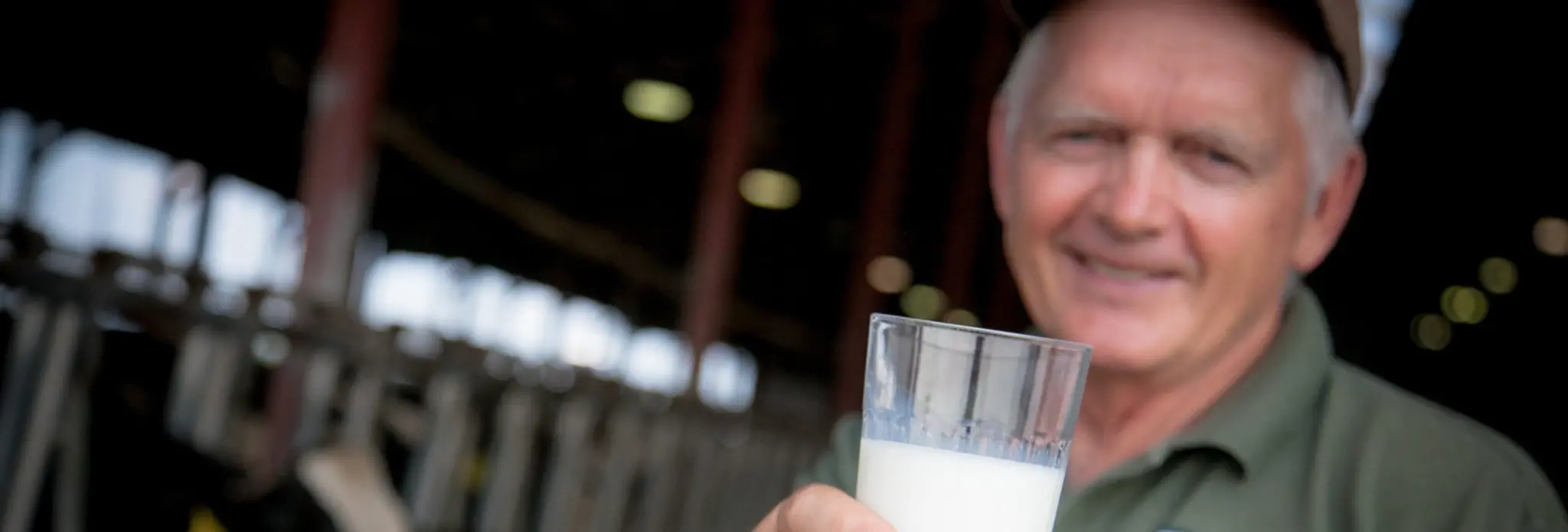 A man holds a glass of milk.
