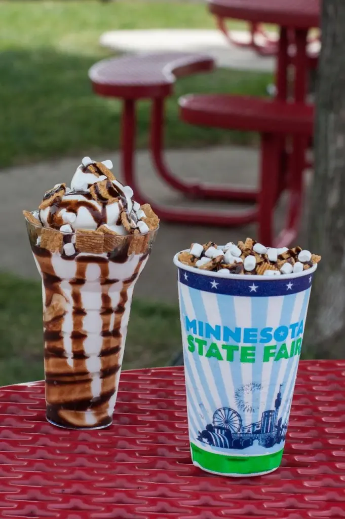 Two smores parfaits sit on a red picnic table.