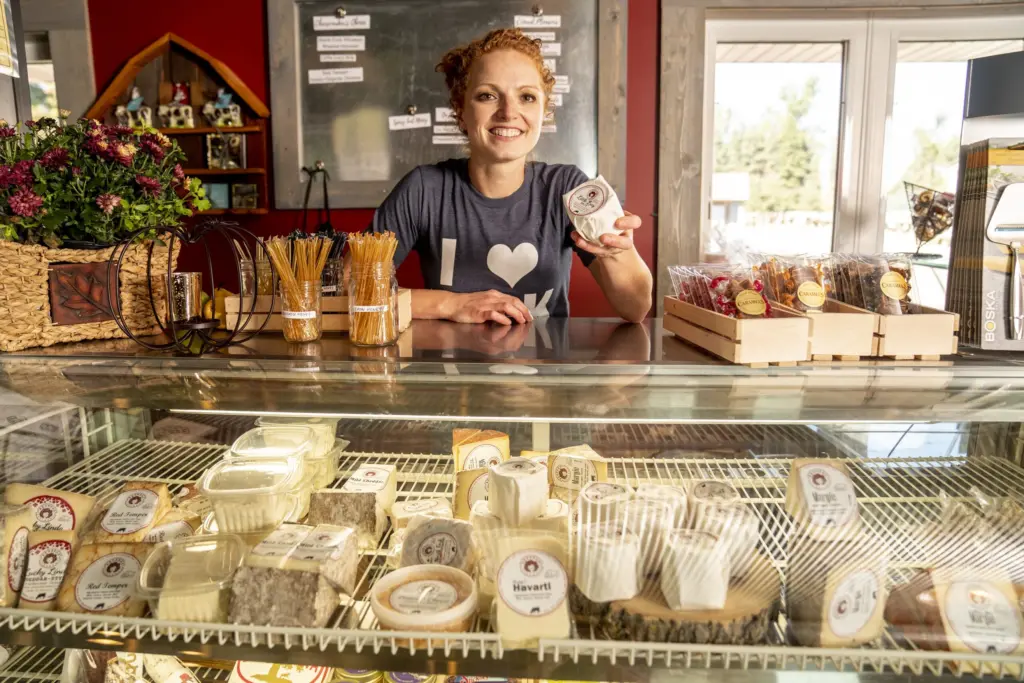 Cheesemaker Alise Sjostrom holds a block of cheese.