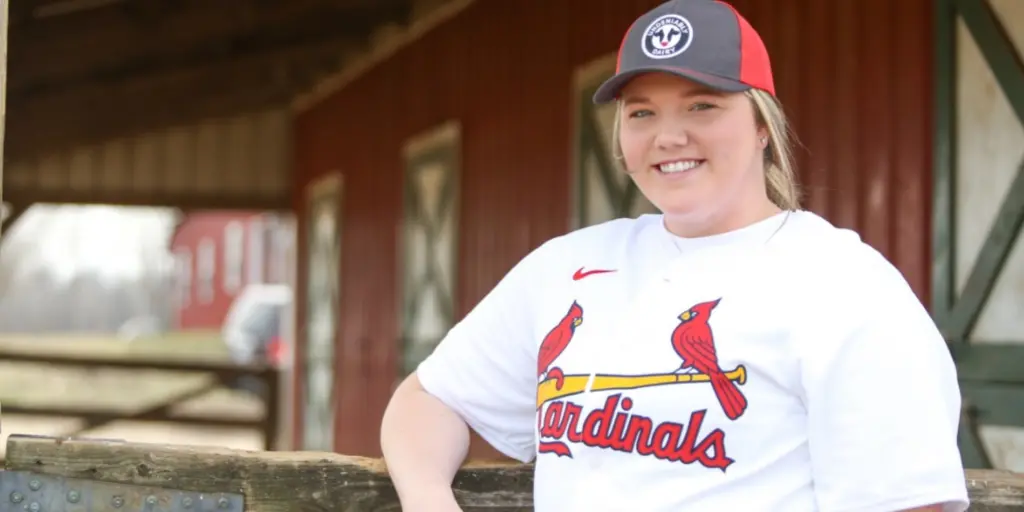 Dairy farmer in baseball shirt with ballcap.