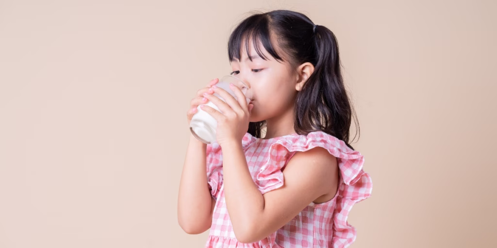 Asian girl drinking class of milk