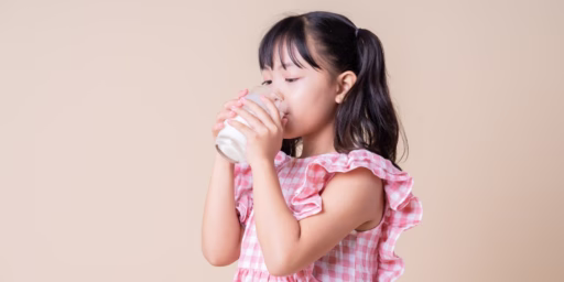 Asian girl drinking class of milk