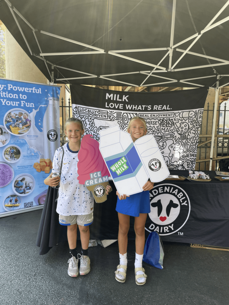 Two children holding milk related props for photo