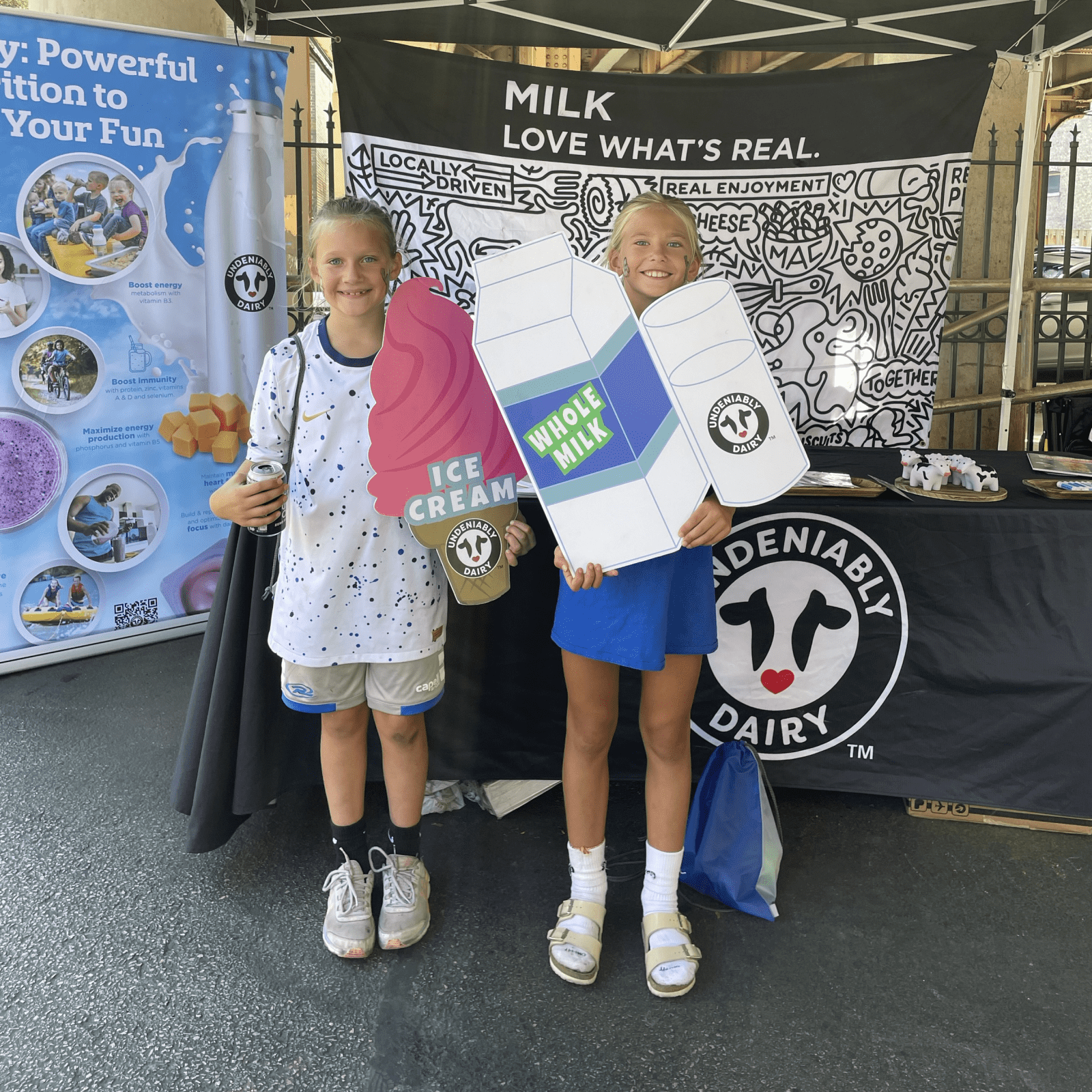 Two children holding milk related props for photo
