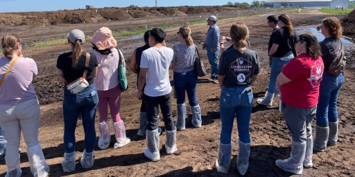 Group of thought leaders listening to dairy farmer during farm tour