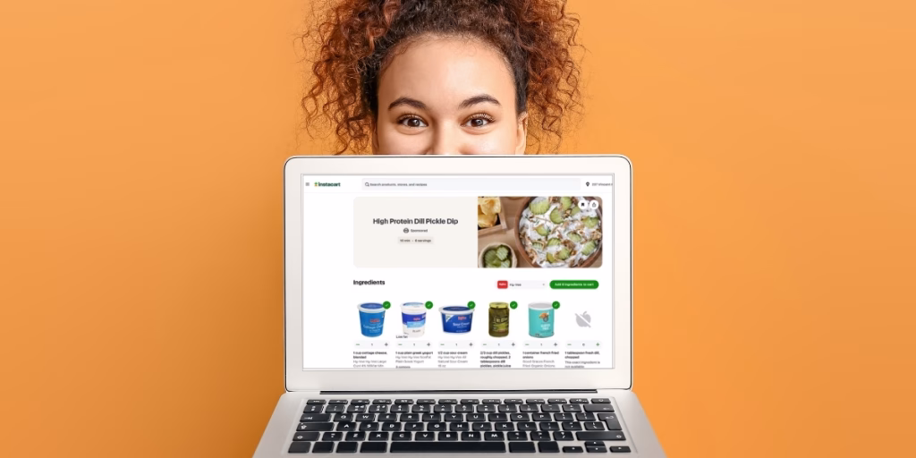 Woman holding laptop showing Instacart ads