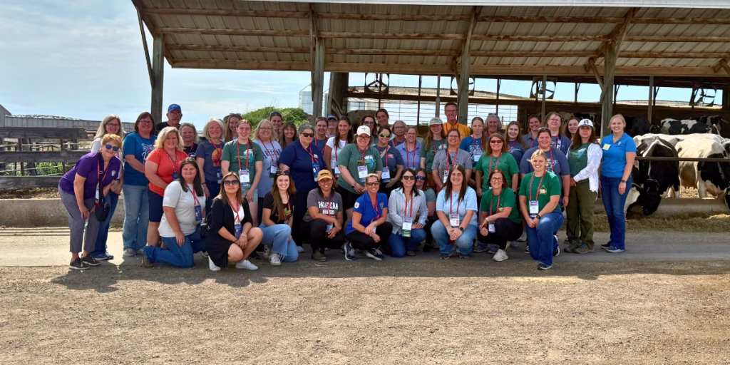 Educators smiling at camera while on dairy farm tour
