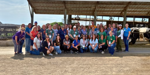 Educators smiling at camera while on dairy farm tour