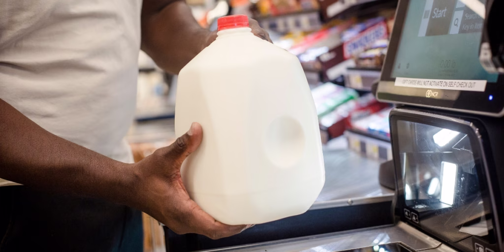 African American man scanning milk at checkout