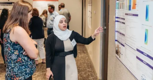 Woman gesturing to research poster