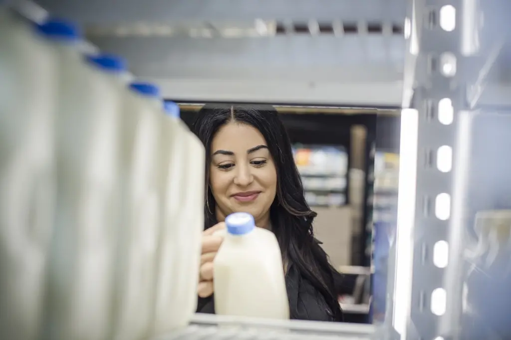 Woman looking at milk jug