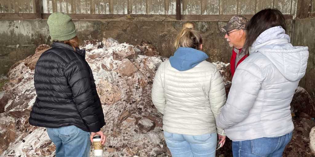 People looking at chocolate being used in cow feed mix
