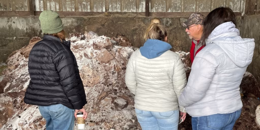 People looking at chocolate being used in cow feed mix