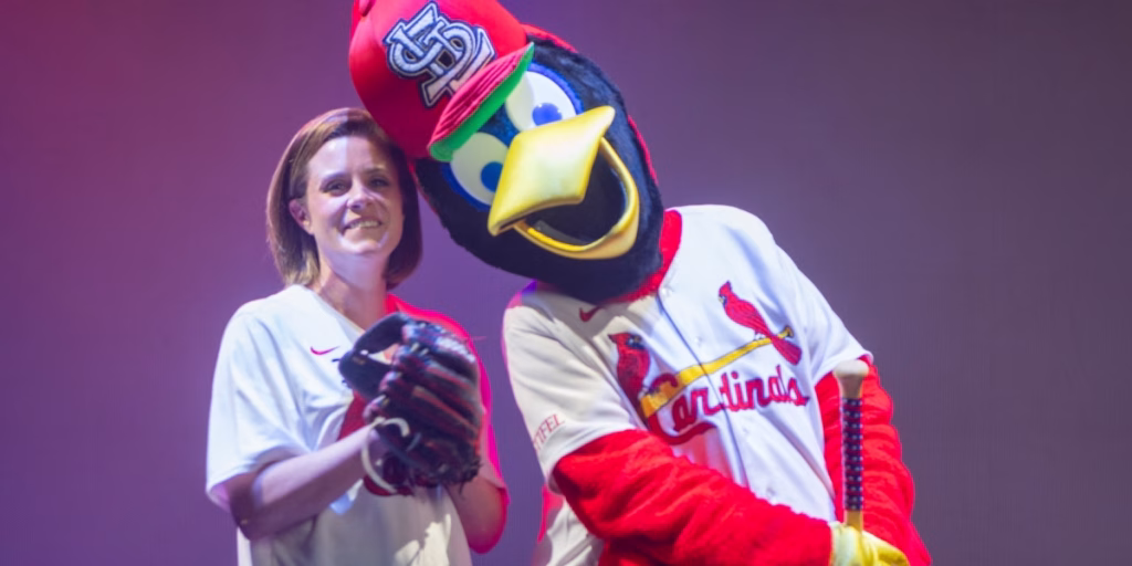 St. Louis Cardinals mascot pointing to woman in Midwest Dairy jersey