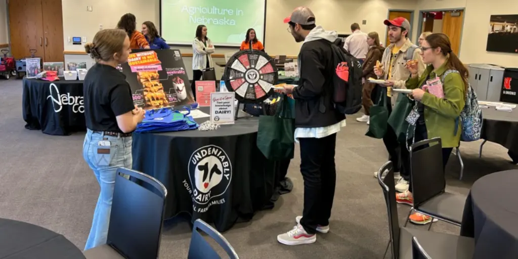 Students looking at dairy booth at event.