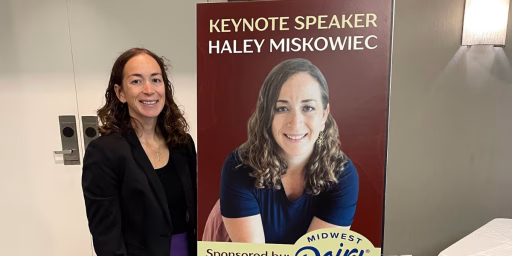 Midwest Dairy Wellness Warrior Haley Miskowiec in front of poster