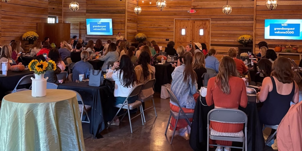 Group of people sitting at tables listening to a speaker