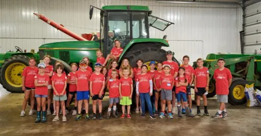 children standing in front of tractor